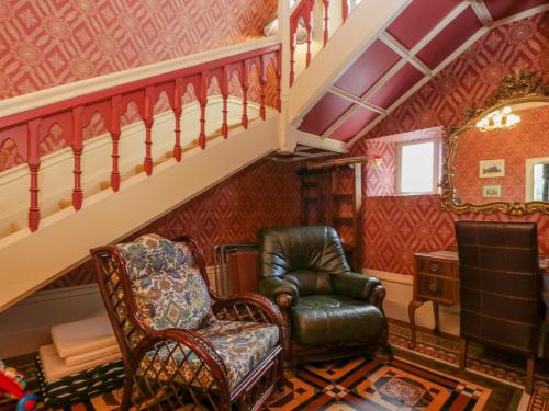 a living room with a chair and a staircase at Millwood Manor in Barrow in Furness