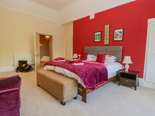 a bedroom with a large bed with a red wall at Millwood Manor in Barrow in Furness