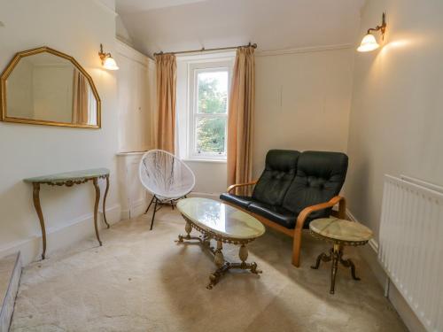 a living room with a black couch and a table at Millwood Manor in Barrow in Furness