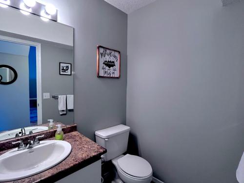 a bathroom with a white toilet and a sink at Canadian Rockies Chalets by Trilink - 2 & 3 Bedroom Condos - Self Check-In - Walking Distance to Downtown - Free Parking - Pet-Friendly - No AC in Canmore