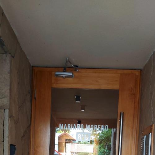 una puerta de madera con un cartel en la parte superior en Departamento centro de san martin de los andes LA NONITA en San Martín de los Andes
