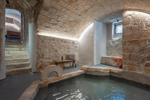 a room with a pool of water in a building at Il Quinto Elemento - Residence Of Charme in Ostuni
