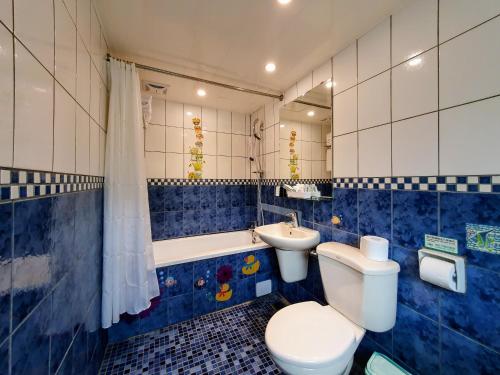 a blue and white bathroom with a toilet and a sink at Rainbow Hotel in Taipei