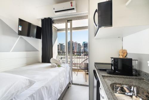 Habitación pequeña con cama y balcón. en VO5 - Studio no Paraíso, Próximo à Paulista e Ibirapuera, com Vaga de Garagem., en São Paulo
