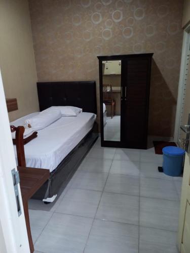 una camera con un grande letto e uno specchio di GRIYA BUNDA a Lumajang