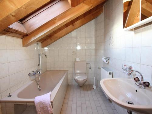 a bathroom with a tub and a toilet and a sink at Bergheimat XL in Winkle
