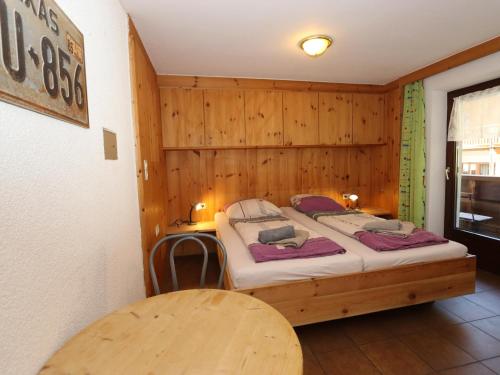 a bedroom with a bed and a wooden wall at Bergheimat XL in Winkle