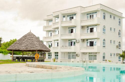 um hotel com piscina e um edifício em Flamingo Naks Suite (Malindi's Hidden Gem) em Malindi