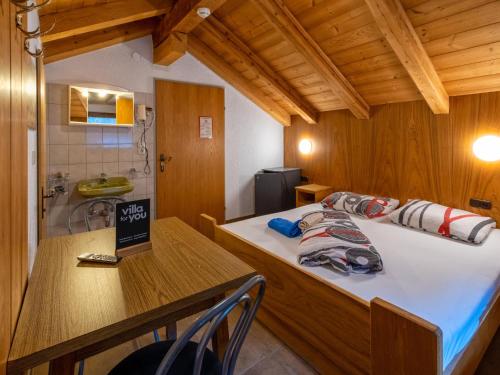 1 dormitorio con cama, mesa y lavamanos en Bergheimat S, en Winkle