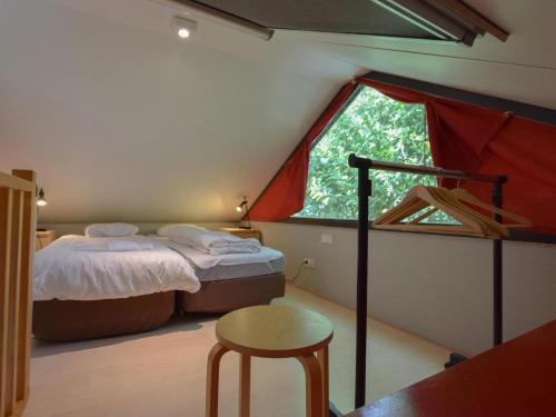 1 dormitorio con cama y ventana grande en Uilenpad 16, en Haaren