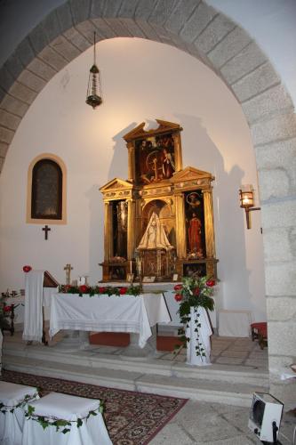 an altar in a church with a large wooden shrine at Parador de Gredos in Navarredonda de Gredos