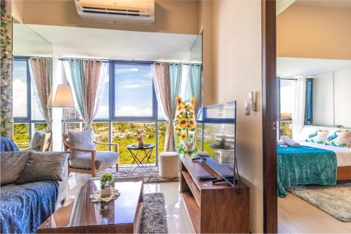 sala de estar con cama y sofá en Mactan Newtown - New Modern Condo with Ocean View en Isla de Mactán