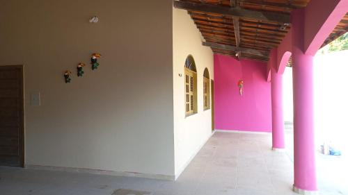 a room with a white wall and pink walls at Pousada Rio e Mar in Fortim