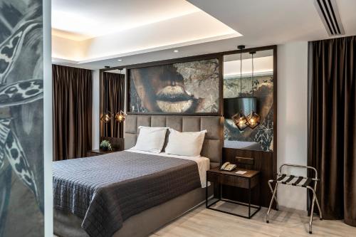 a hotel room with a bed and a painting on the wall at Almond Business Hotel in Nicosia