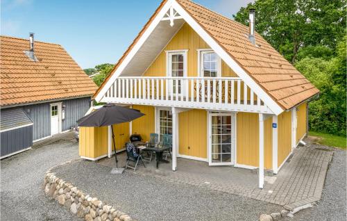 a yellow house with a table and an umbrella at Awesome Home In Gråsten With Sauna in Gråsten