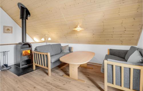 a living room with a table and a wood stove at Awesome Home In Gråsten With Sauna in Gråsten