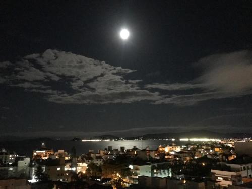 a view of a city at night with the moon at Cobertura Duplex - La Belle Vue - Canajurê in Florianópolis