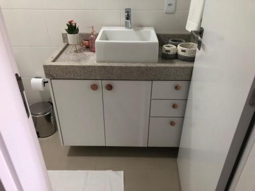 a white bathroom with a sink and a counter at Cobertura Duplex - La Belle Vue - Canajurê in Florianópolis