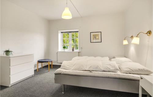 a white bedroom with a bed and a desk at Nice Home In Kværndrup With Kitchen in Kværndrup