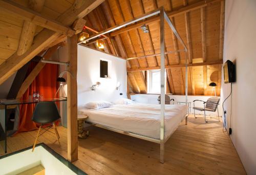 una camera con letto in una stanza con soffitti in legno di Restaurant Hotel Buitenlust ad Amerongen