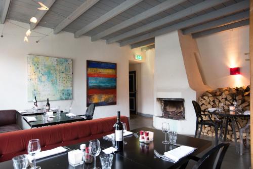 a restaurant with a red couch and a fireplace at Restaurant Hotel Buitenlust in Amerongen