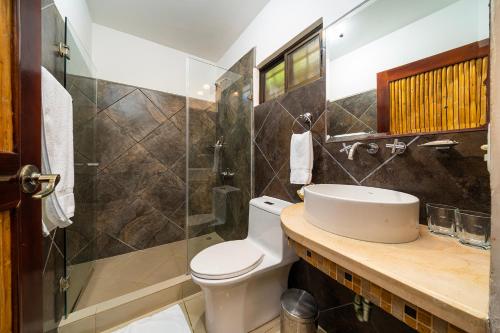 a bathroom with a toilet and a sink and a shower at Hotel Arco Iris in Tamarindo