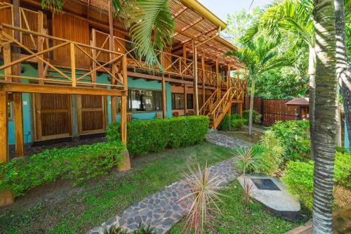 a building with a palm tree in front of it at Hotel Arco Iris in Tamarindo