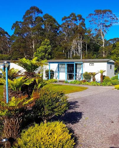 a white house with a driveway in front of it at Strahan Retreat Holiday Park in Strahan