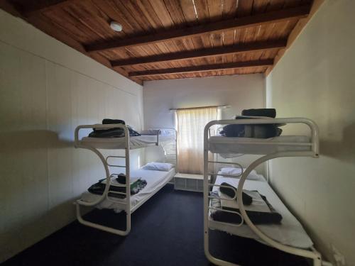 a room with two bunk beds and a wooden ceiling at Strahan Retreat Holiday Park in Strahan