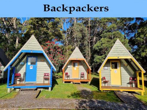 a group of cottages sitting in the grass at Strahan Retreat Holiday Park in Strahan