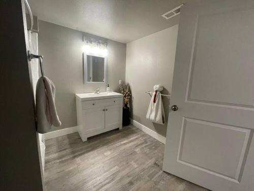 a bathroom with a sink and a mirror and a door at Quaint new renovation perfect for your large group in Billings