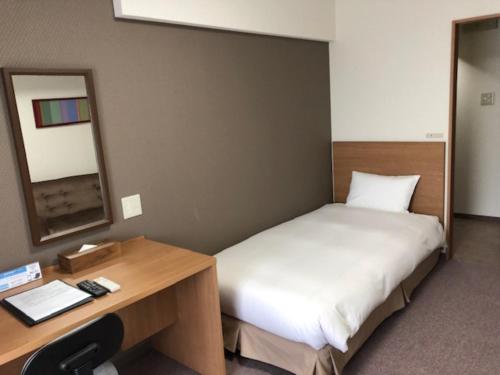 Un pat sau paturi într-o cameră la Hotel Sapporo Met's