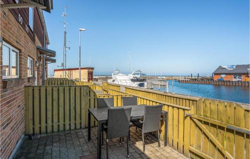 a table and chairs on a balcony with a boat at 2 Bedroom Awesome Home In Glesborg in Glesborg