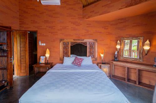 a bedroom with a large bed in a room with wooden walls at Villa Kanha by Bukit Vista in Jimbaran