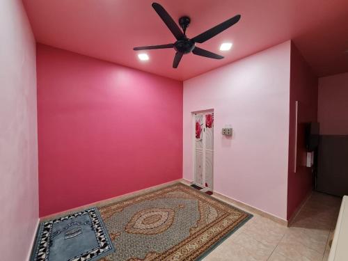 a room with a ceiling fan and a pink wall at HOMESTAY EPOH MANJOI WITH PRIVATE POOL AND JACUZZI in Ipoh