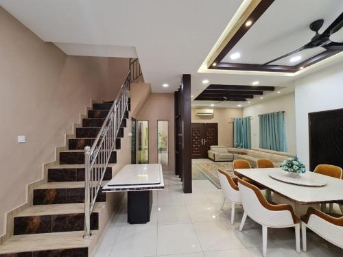 a dining room with a staircase and a table and chairs at HOMESTAY EPOH MANJOI WITH PRIVATE POOL AND JACUZZI in Ipoh