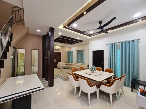 a dining room and living room with a table and chairs at HOMESTAY EPOH MANJOI WITH PRIVATE POOL AND JACUZZI in Ipoh