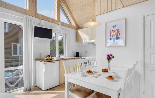 a kitchen and dining room with a white table and chairs at Cozy Home In Tranekær With Kitchen in Tranekær