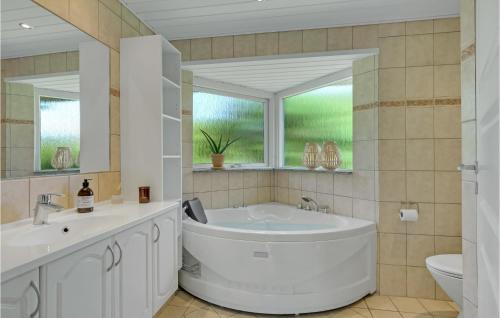 ein Bad mit einer Badewanne, einem Waschbecken und einem Fenster in der Unterkunft Lovely Home In Gilleleje With Wifi in Gilleleje