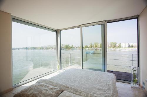 a bedroom with a large window with a view of the water at Villa Infinity Floating in Belgrade