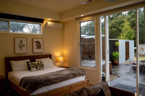 1 dormitorio con 1 cama y puerta corredera de cristal en Deville At Healesville, en Healesville