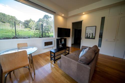 a living room with a couch and a table at Deville At Healesville in Healesville