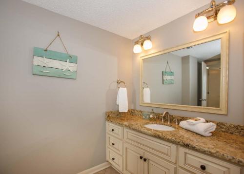 a bathroom with a sink and a mirror at Shoalwater 802 in Orange Beach