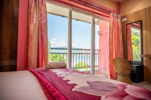 a bedroom with a bed and a large window at The Seaview Residency in Port Blair