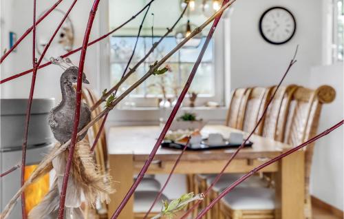 a dining room with a bird sitting on a branch at Awesome Home In Lemvig With Kitchen in Lemvig