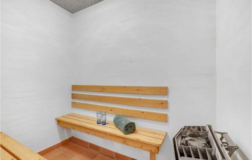 a wooden bench sitting in a corner of a room at Awesome Home In Lemvig With Kitchen in Lemvig