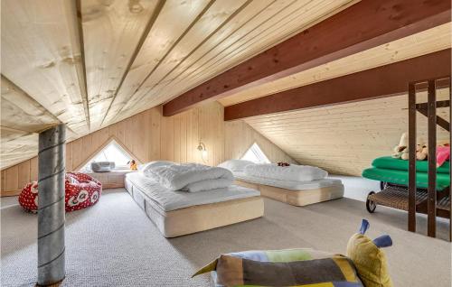 a bedroom with two beds in a room with wooden ceilings at Awesome Home In Lemvig With Kitchen in Lemvig