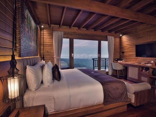 a bedroom with a bed with a view of the ocean at Elevate Bali in Munduk