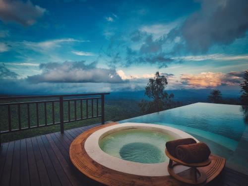 a jacuzzi tub on a deck with a view at Elevate Bali in Munduk