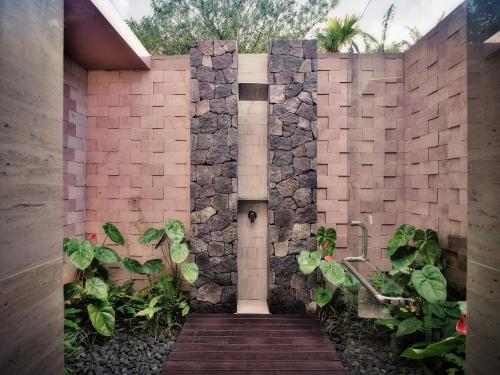 a building with a stone wall with a pathway at Elevate Bali in Munduk